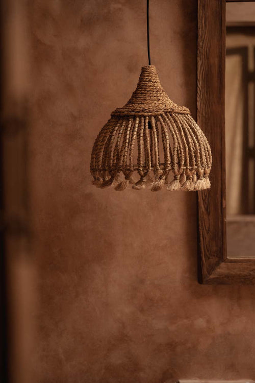 Abaca Tassel Pendant Light – Natural, Small – styled against a warm brown wall