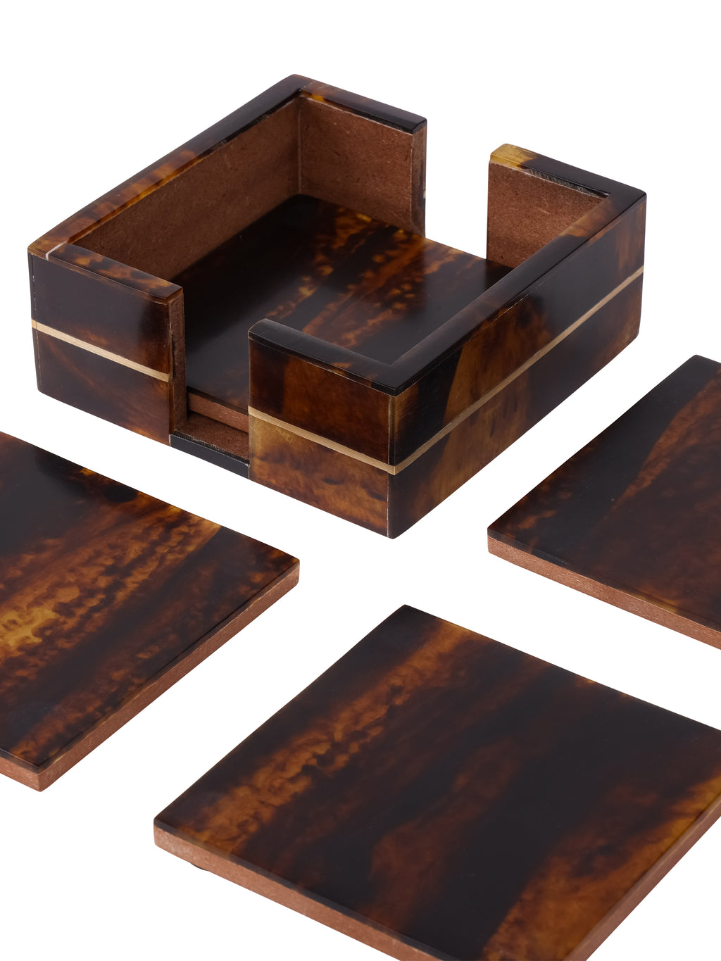 Close view of the patterned coaster holder, showing its brass line, open sides and brown interior, with loose coasters around it.