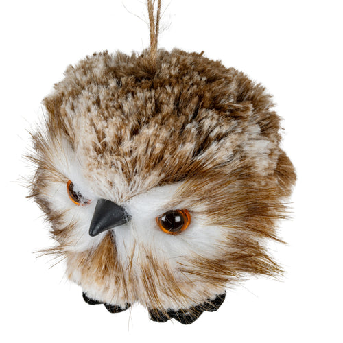 Angled close-up of the owl decoration showing its mottled pile, sweeping white and brown facial fibres, glossy amber-rimmed eyes and projecting matte-black beak.