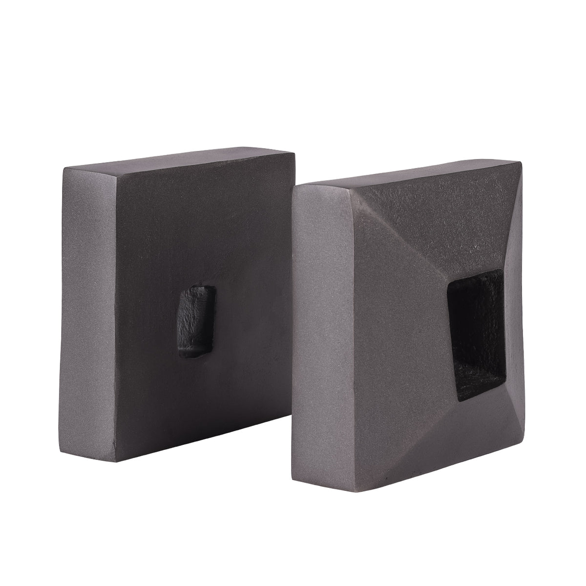 Charcoal grey bookends at an angle, showing one broad rear face with a small opening and one faceted face with a deep recess.