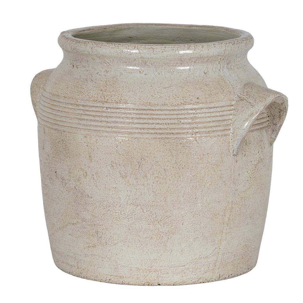 Cream planter viewed at an angle, showing its open flared rim, banded shoulders and projecting right-hand handle.