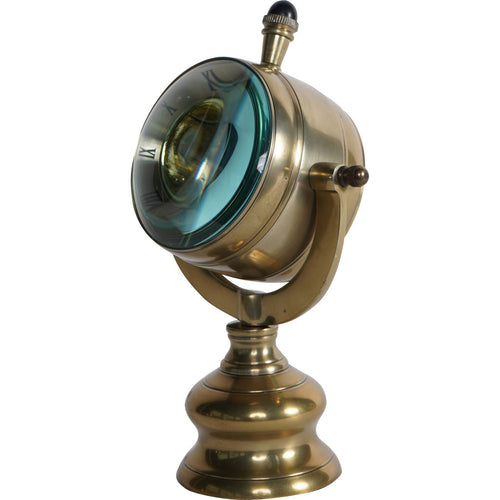 Angled view showing the clock's deep drum case, outward-curving transparent front and dark-capped crown.