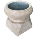 Angled view of a pale wooden candle holder with a faceted base, rounded top and dark inset candle plate with a central spike.