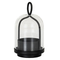 Black candle holder with a deep round cup, stepped base and arched frame beneath a clear bell-shaped cloche, topped by an oval loop.