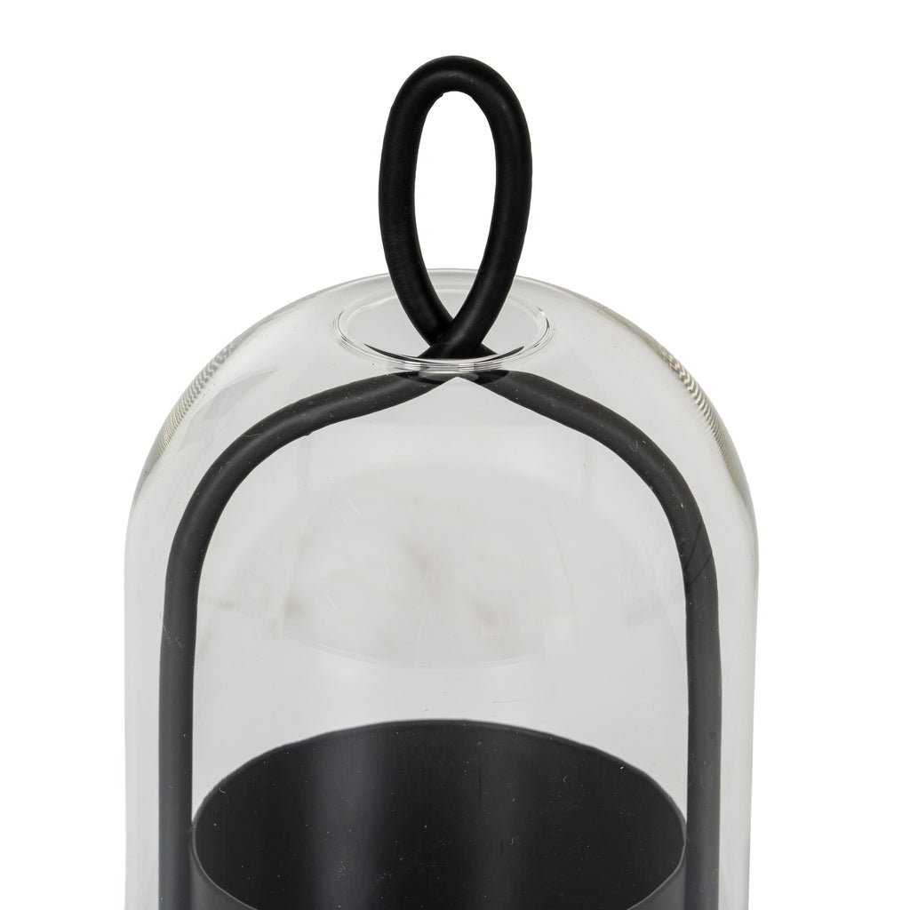 Close-up of the oval black loop above the rounded clear cloche, with the curved side frame and open candle cup visible below.