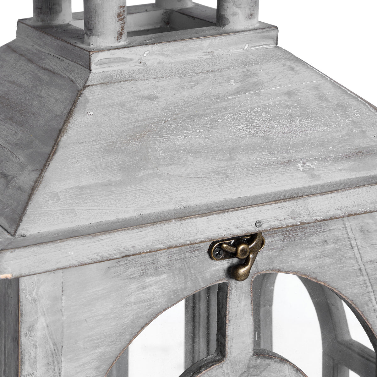 Close-up of the lantern roof and front clasp, showing rubbed pale grey colouring and the top of an arched frame.