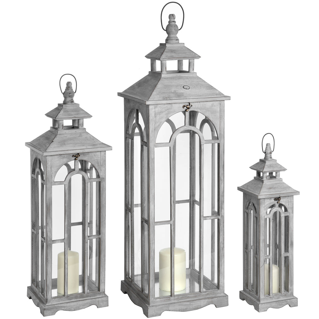 Three pale grey Archwindow lanterns in graduated sizes, with pitched roofs, loop tops and cream pillar candles shown inside.