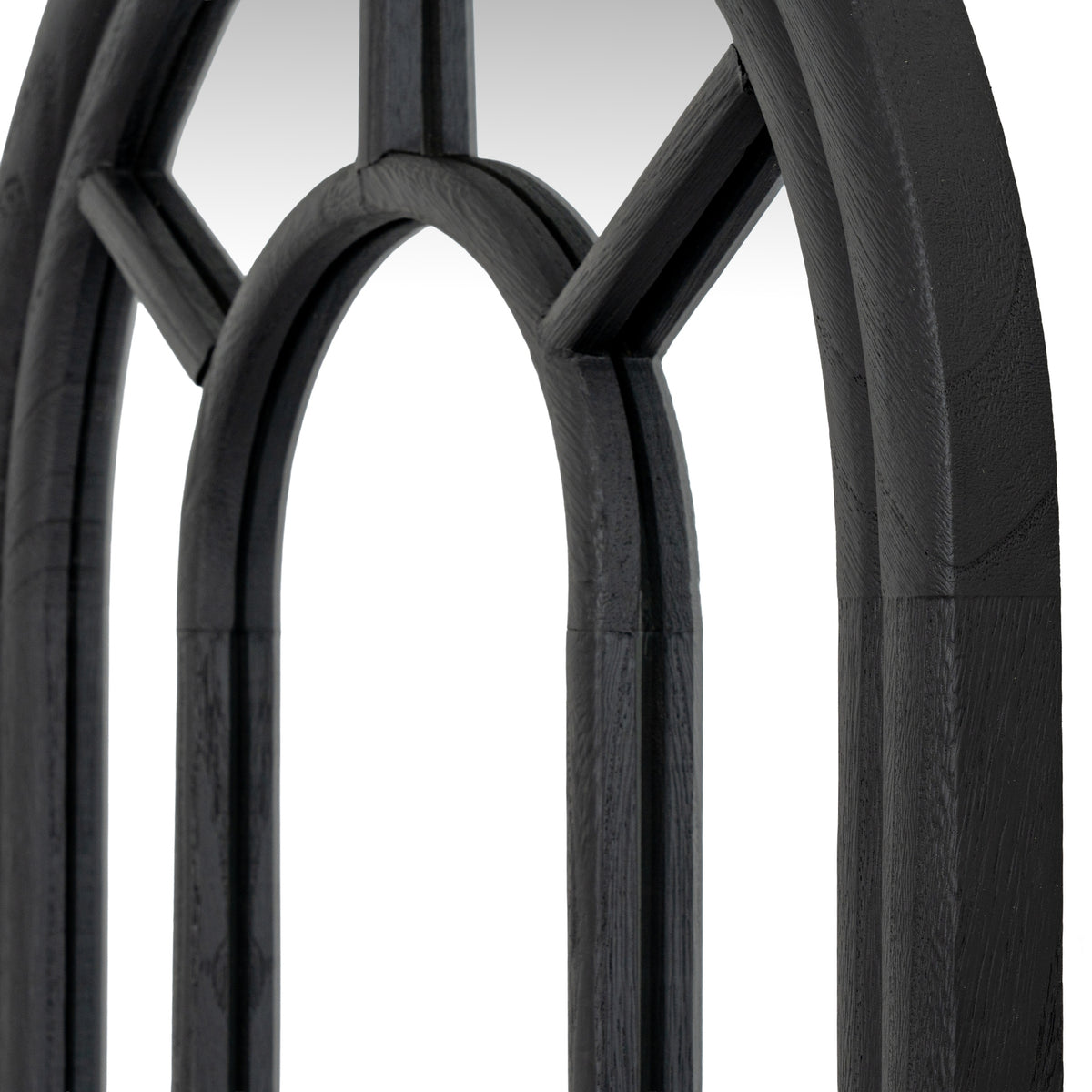 Angled close-up of the mirror's inner arch and diagonal bars, showing grain-like texture on the black surfaces.