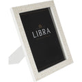 Angled front view of a white photo frame with pale geometric bone inlay, a black display insert and its rear stand extended.