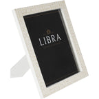 Angled front view of a white photo frame with pale geometric bone inlay, a black display insert and its rear stand extended.