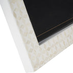 Close-up of the lower frame corner with cream geometric inlay, white side edge and the inset glass front.