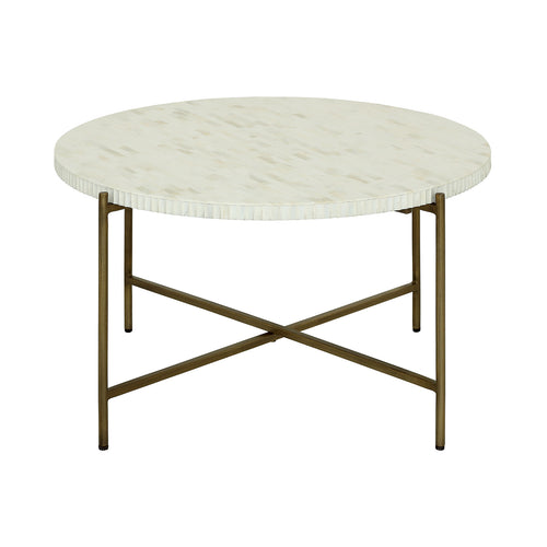 Atrium coffee table viewed at an angle, showing its pale circular inlay top and aged brass-coloured frame with crossing rails.