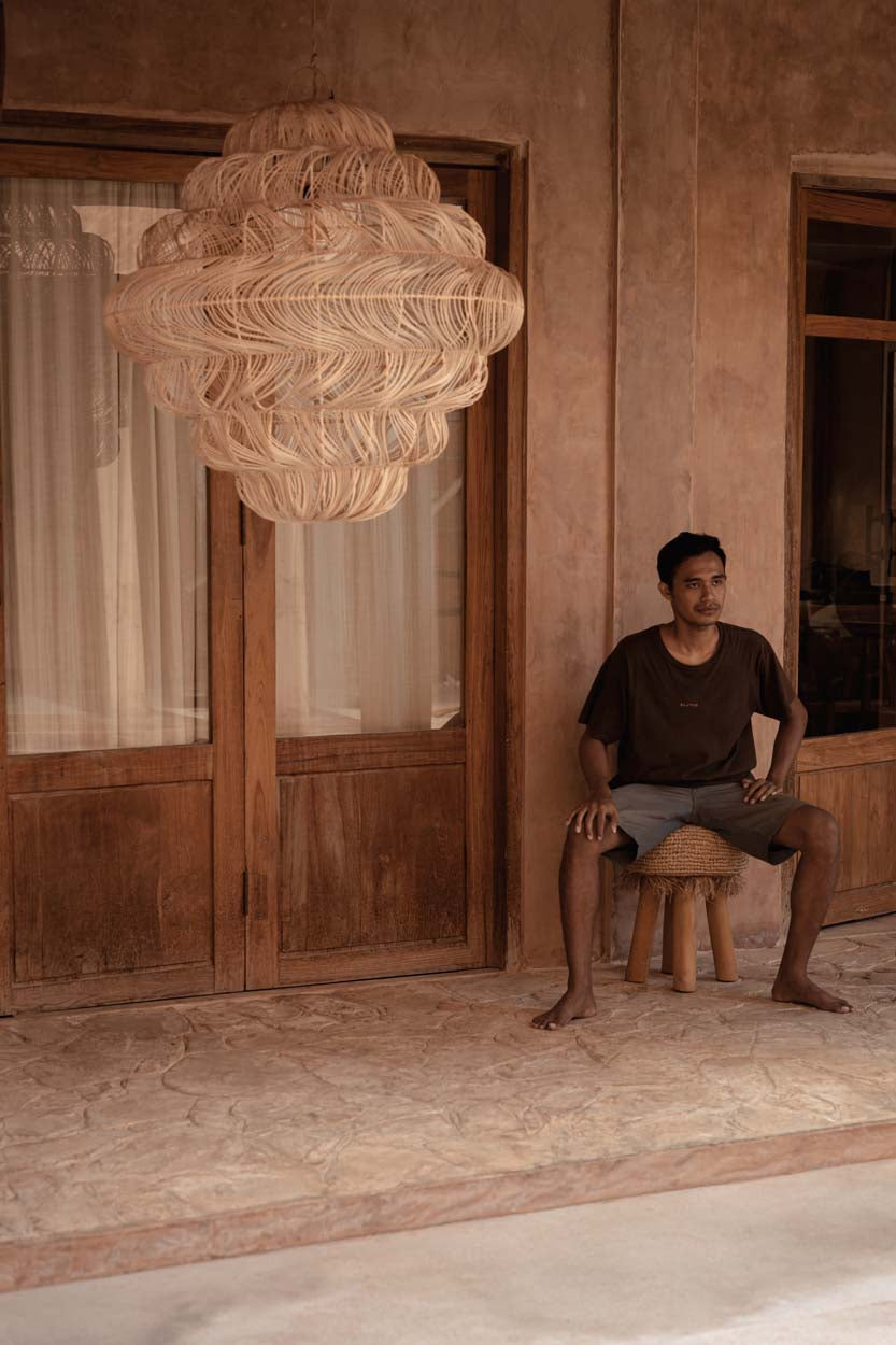 Aurora Puff Rattan Pendant Light – Natural, Extra Large – styled in a doorway with a seated person