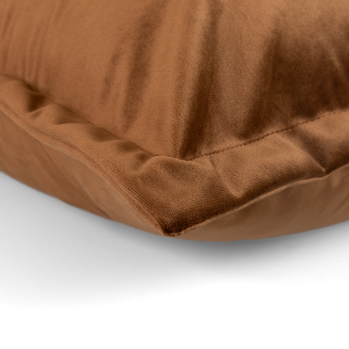 Close-up of the caramel velvet corner and piped edge on the Aveline Cushion
