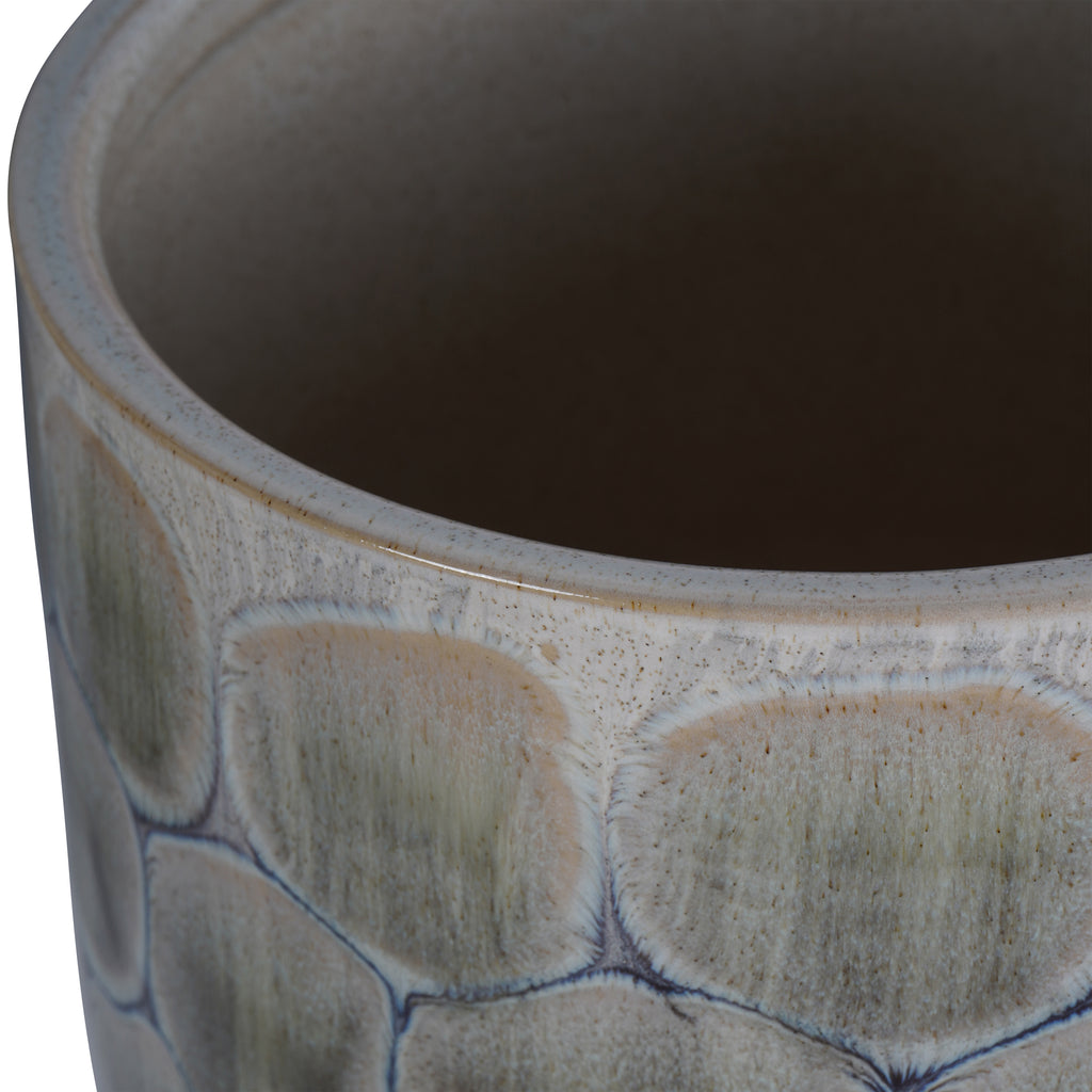 Close view of the planter's rounded rim and interior, with pale speckled glaze above the blue-outlined cell pattern.