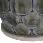 Close-up of grey glazed cells edged in blue above the planter's speckled sand-coloured ceramic base.