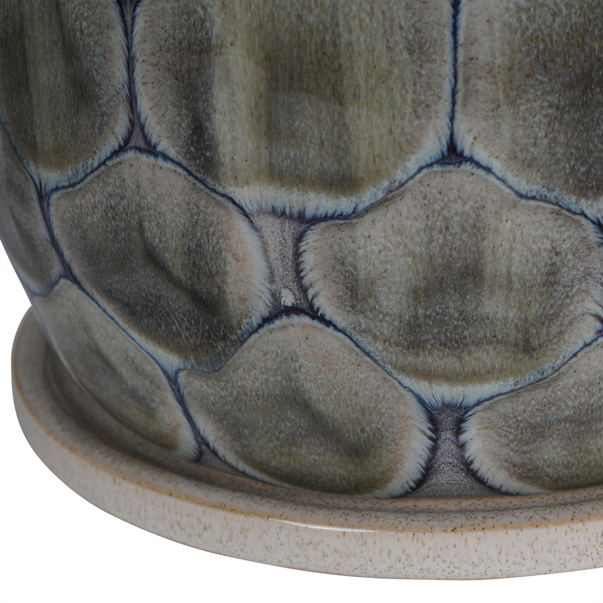 Close-up of grey glazed cells edged in blue above the planter's speckled sand-coloured ceramic base.