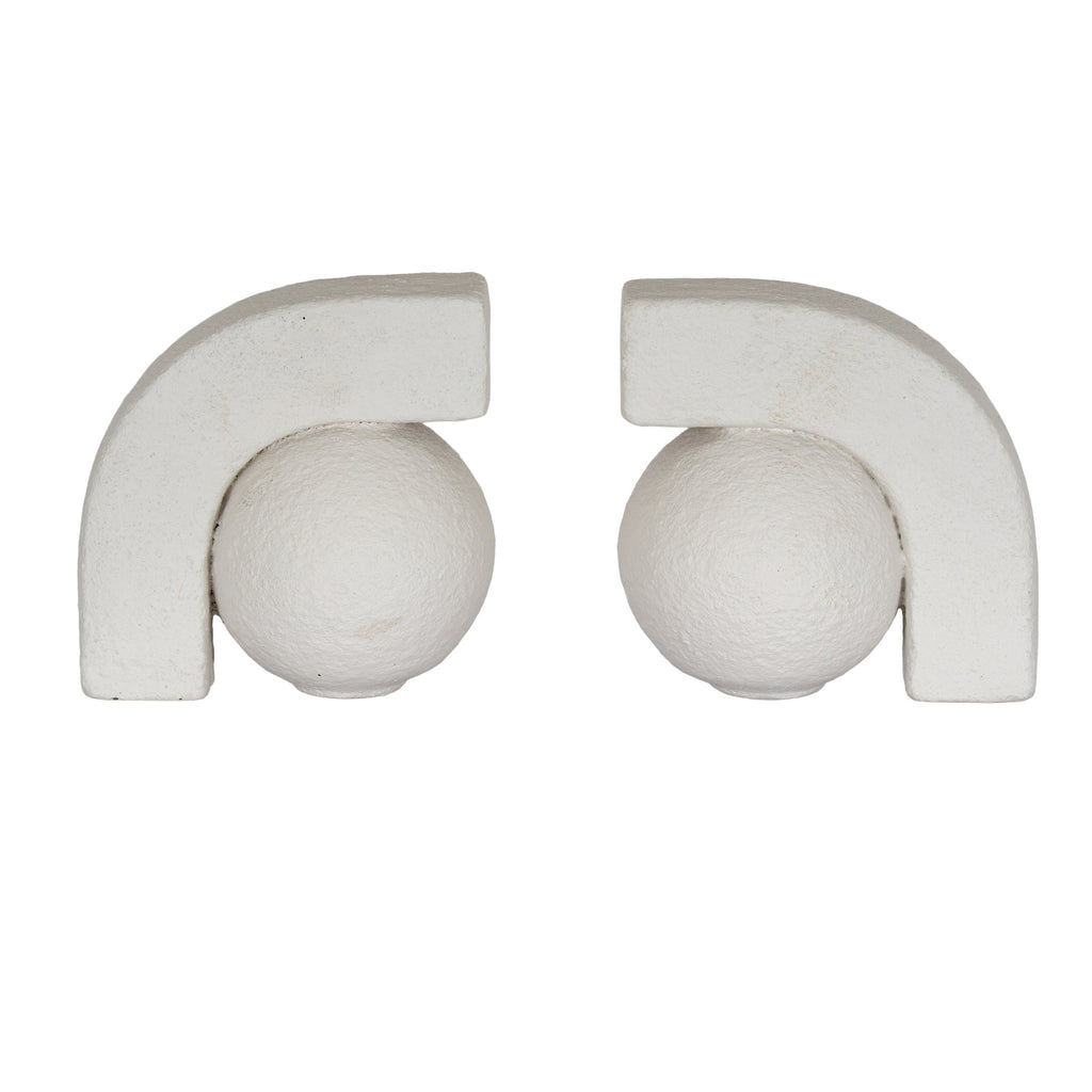 Two off-white ball-and-arch bookends facing one another against a white background, with textured spheres beneath thick squared arches.