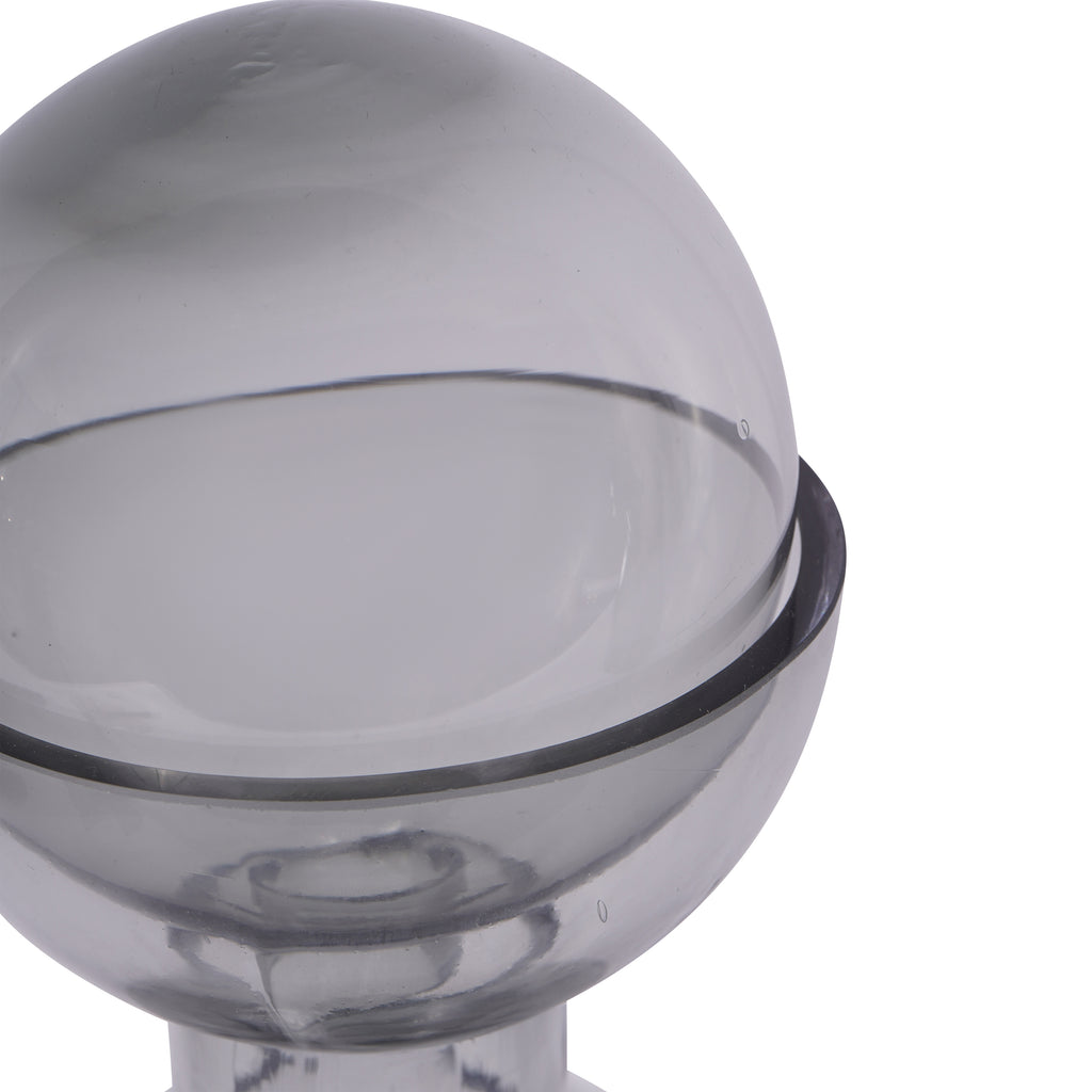 Close-up of the smoky glass ball resting inside the vase rim, with reflections and small bubbles visible in the glass.