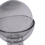 Close-up of the smoky glass ball resting inside the vase rim, with reflections and small bubbles visible in the glass.