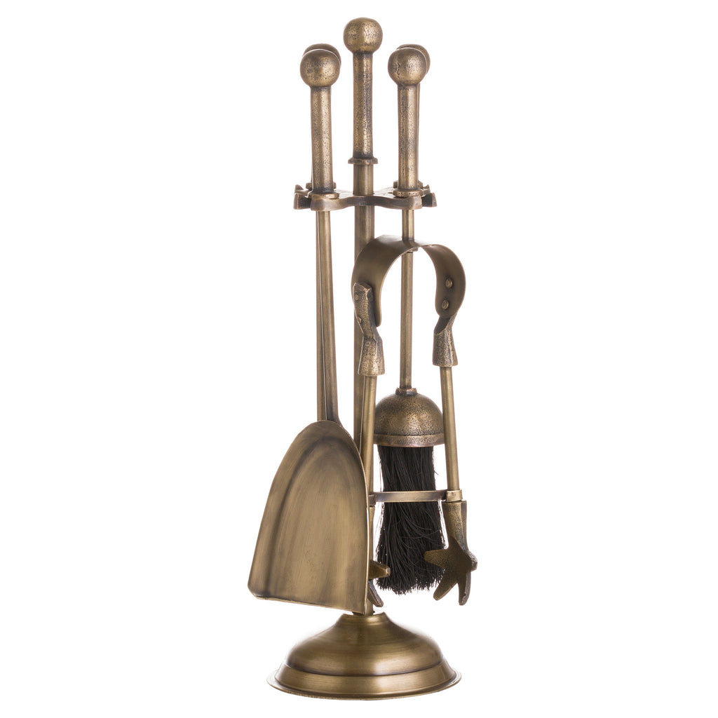 Alternate view of the yellow-brown fireside companion set, showing the broad shovel face on the left, curved tongs on the right and black brush behind the shafts.