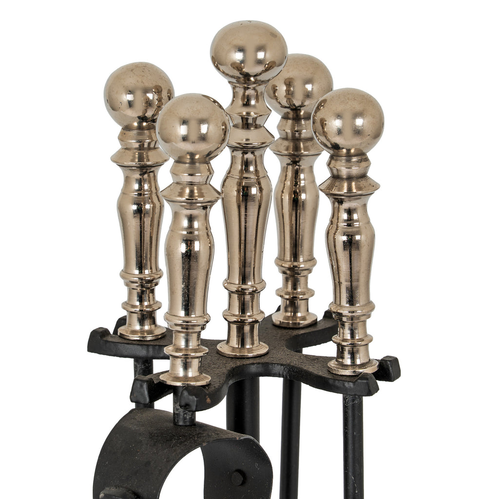 Close-up of five reflective silver-toned ball finials above the black rack, with the central finial standing tallest.