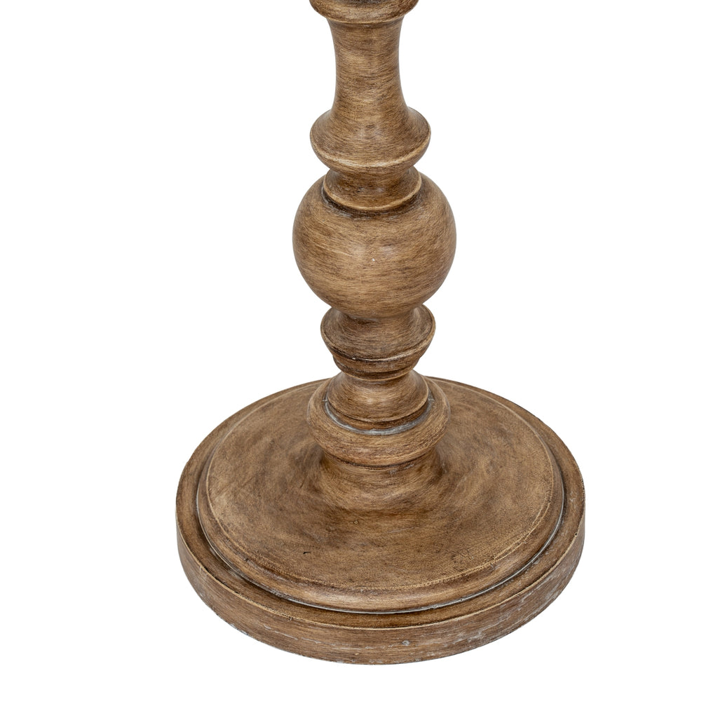 Close-up of the lamp's circular stepped base and lower rounded bead, showing lighter marks along the brown edges.