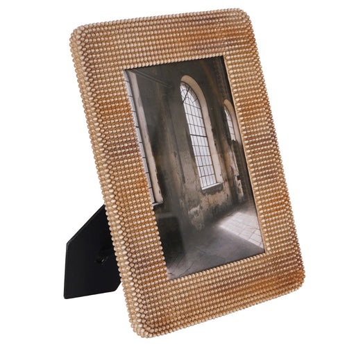 Angled front view of the brown beaded photo frame with its black easel support visible behind.