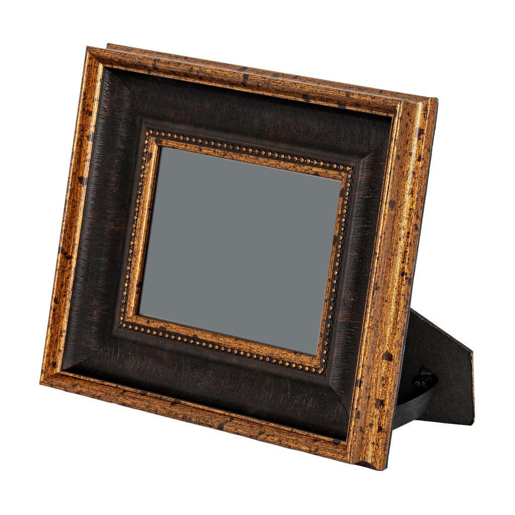 Photo frame standing at an angle on its rear easel, with a plain grey centre and beaded gold-toned inner trim.