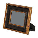 Photo frame standing at an angle on its rear easel, with a plain grey centre and beaded gold-toned inner trim.