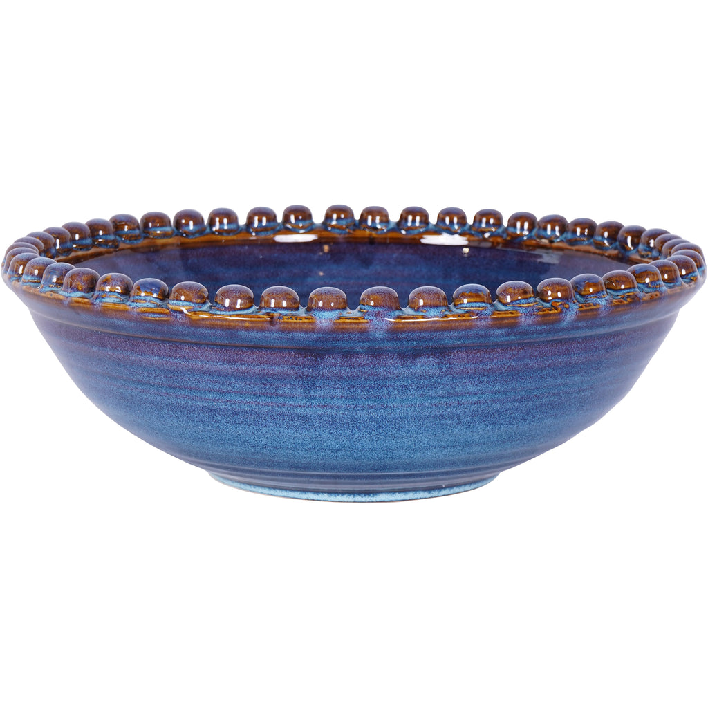 Blue ceramic bowl viewed at an angle, showing its curved body, open interior and brown and blue beaded rim.