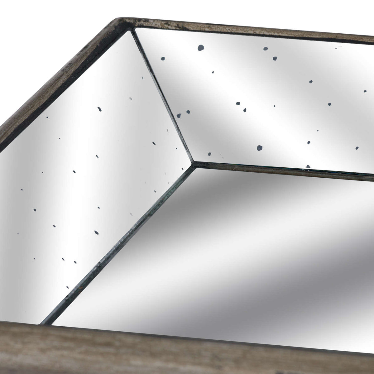 Close-up of a tray corner showing dark joins between angled mirror panels, scattered distressed spots and the mottled outer rim.