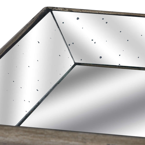 Close-up of a tray corner showing dark joins between angled mirror panels, scattered distressed spots and the mottled outer rim.