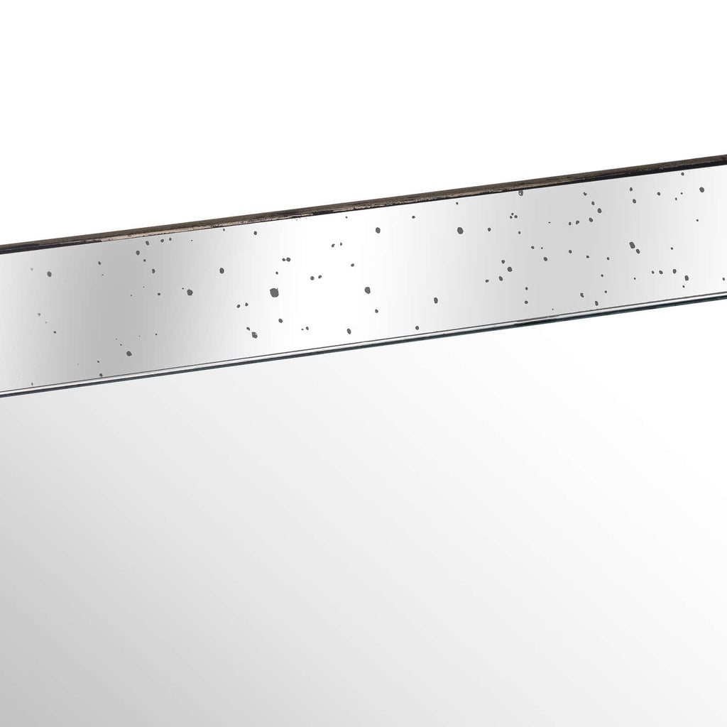 Close-up of the tray's mirrored inner side with scattered dark speckles, a slim distressed rim and the reflective base below.