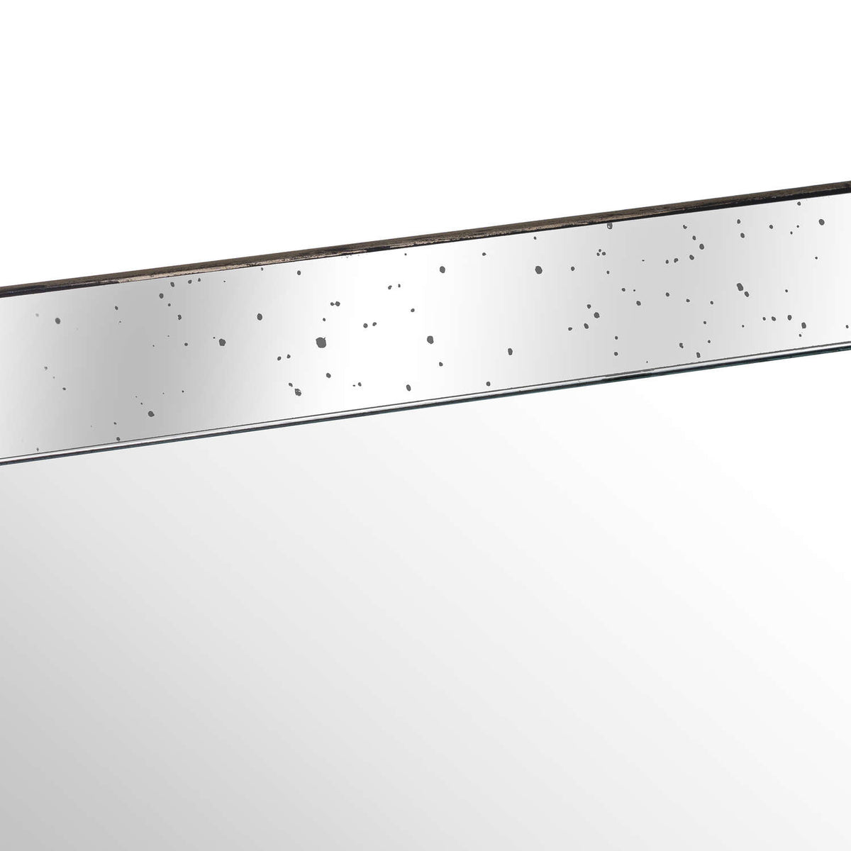Close-up of the tray's mirrored inner side with scattered dark speckles, a slim distressed rim and the reflective base below.