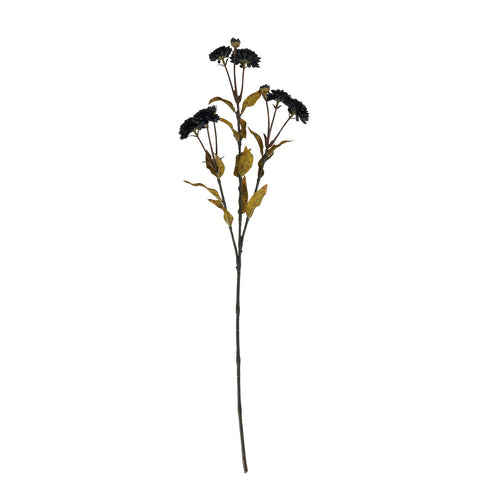 Full view of a dark artificial flower stem with branching black blooms, small buds and yellow-brown leaves against white.