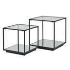 Two black framed side tables on a white background, with the shorter table in front and square reflective surfaces above and below.