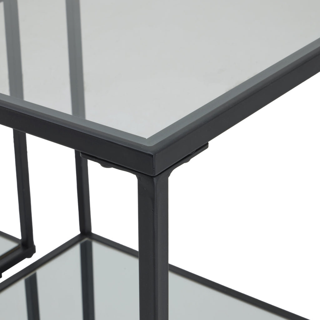 Close view of a side table's upper corner, showing the black border, vertical frame and reflective surface.