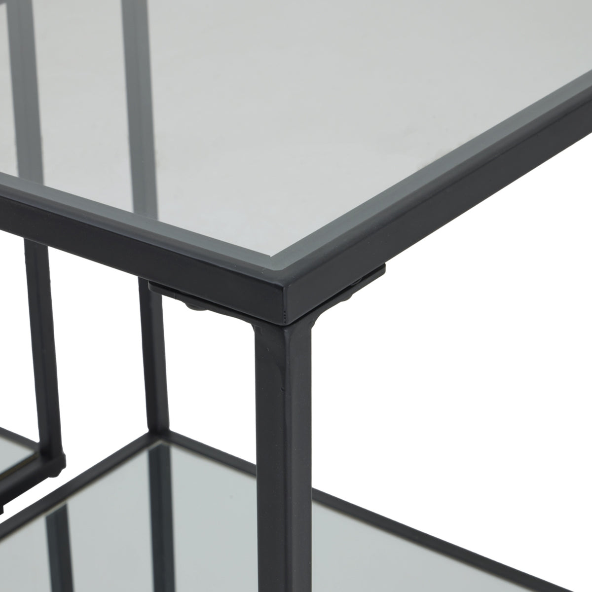 Close view of a side table's upper corner, showing the black border, vertical frame and reflective surface.