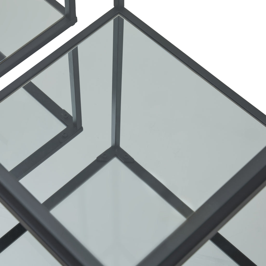 Angled close-up of a reflective lower shelf, with black frame edges and upright reflections forming intersecting lines.