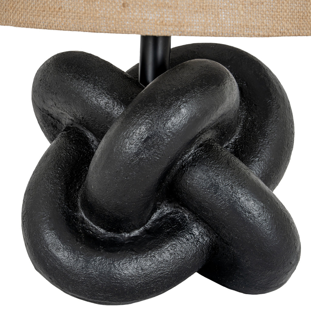 Close-up of the lamp's thick interlocking black loops, showing their textured surface beneath the woven shade.
