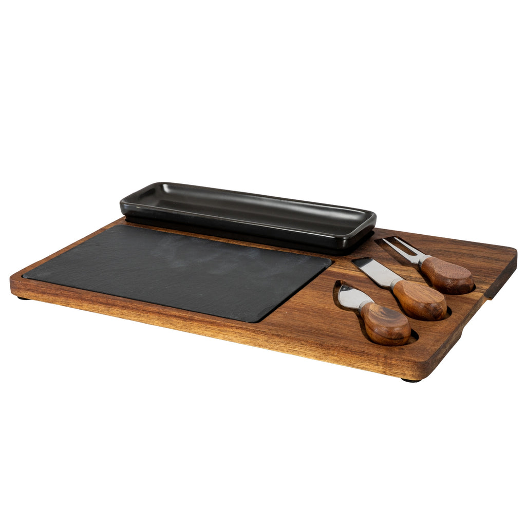 Angled view of a brown grained cheese board with a long glossy black dish, dark rectangular insert and three brown-handled utensils in fitted recesses.