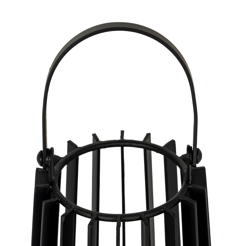Close-up of the lantern's rounded black handle and side pivots above the circular opening and projecting vertical slats.