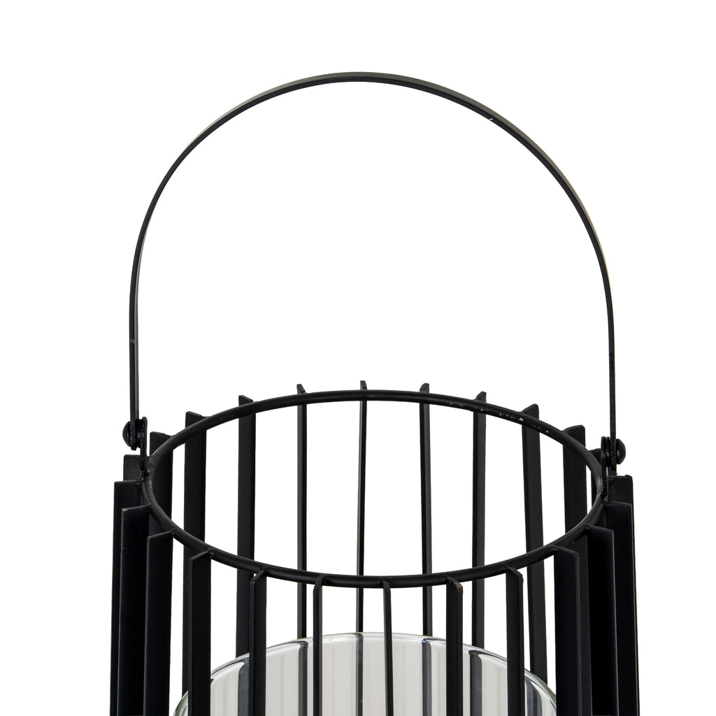Close-up of the lantern's upright arched handle and circular open top, showing the broad fins between slender vertical rods.