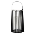 Full view of a tall black lantern with an upright arched handle, vertical rods, broad outer fins and a clear cylindrical inner holder.