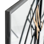 Angled close-up of a black frame corner beside the mirrored clock face, with curved black dial bars and gold-coloured numerals behind.