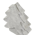 Angled close-up of the tree ornament's pointed top and broad branch tiers, showing mottled white-grey colouring and darker edges.