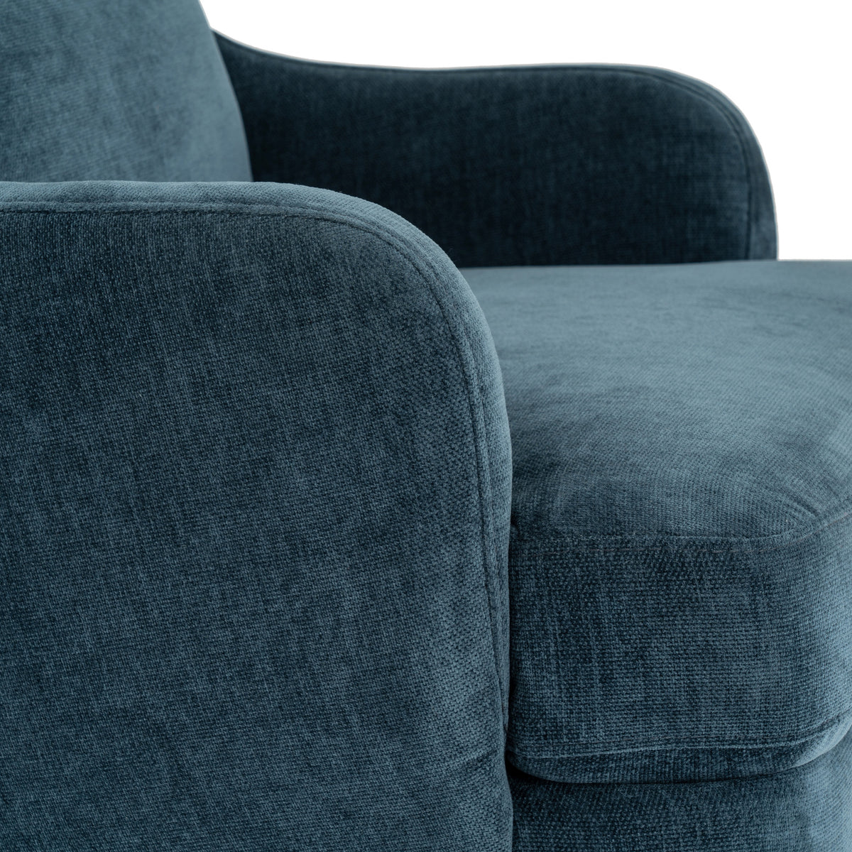 Close-up of the blue upholstery, showing fine surface texture and seams around the curved arm and seat cushion.