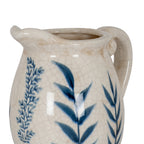 Close-up of the vase's open mouth, curved lip and handle above blue foliage on a glossy off-white crackle surface.