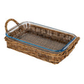 Angled view of an empty transparent rectangular dish with rounded corners and a blue-tinted rim, sitting in a brown woven tray with loop handles at both ends.